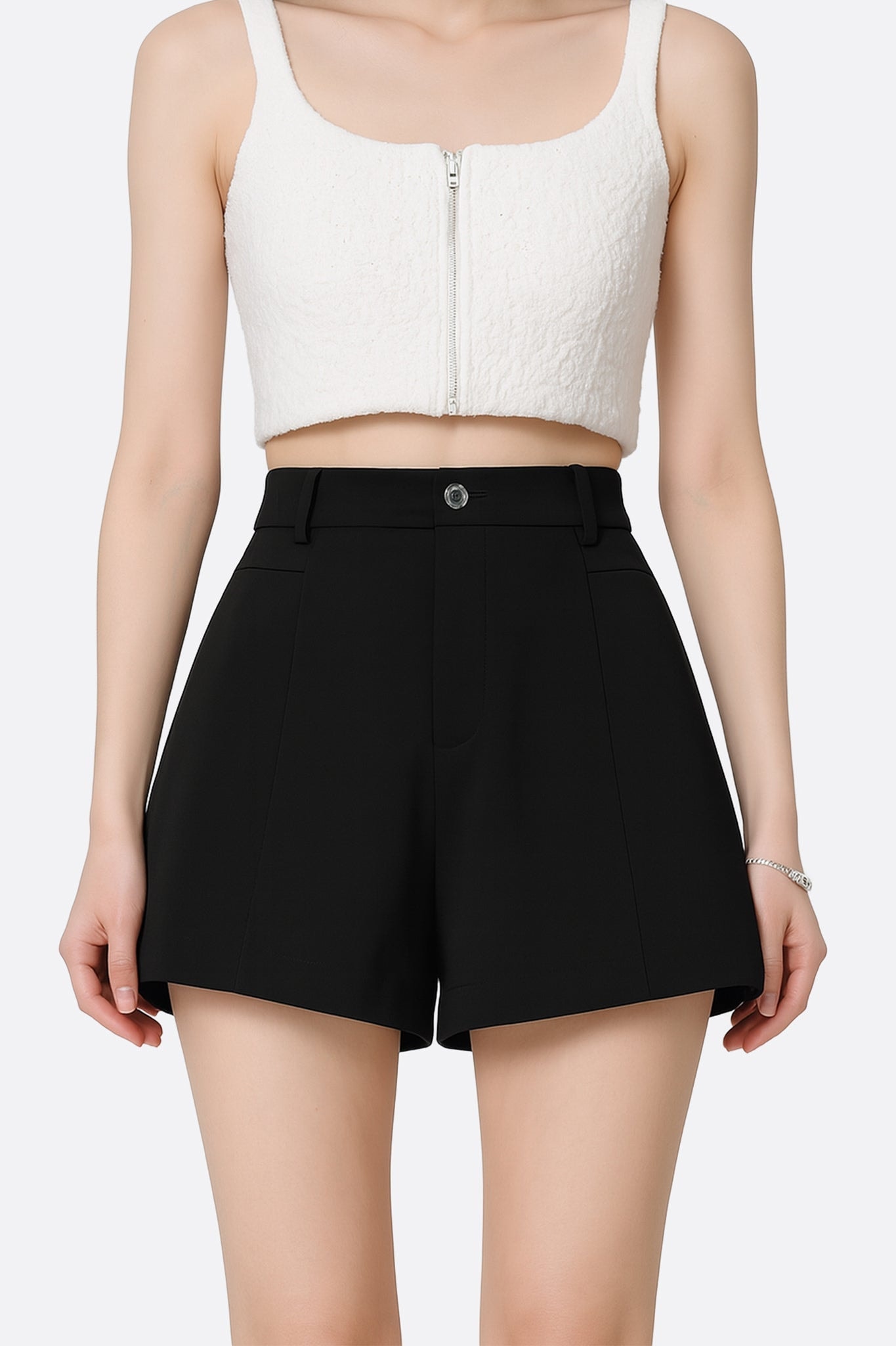 Détails raffinés du short noir taille haute à pinces, idéal pour un look moderne et sophistiqué.