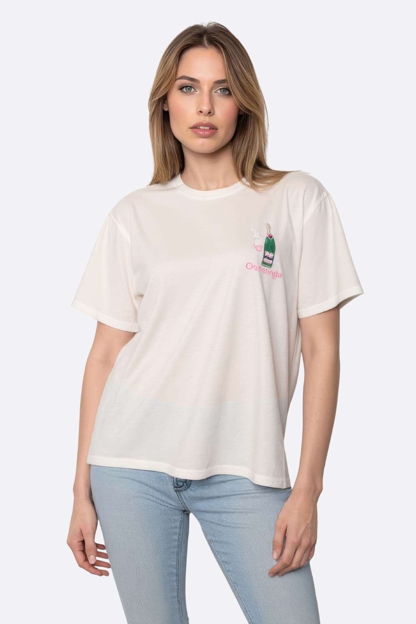 Chic oversized white t-shirt featuring vibrant embroidery of a champagne bottle and glass, perfect for festive occasions.
