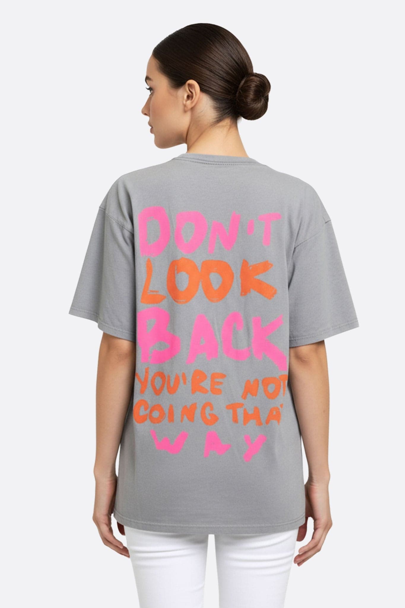 Detalle de la camiseta gris holgada de algodón, destacando un mensaje vibrante para un conjunto casual y con estilo.