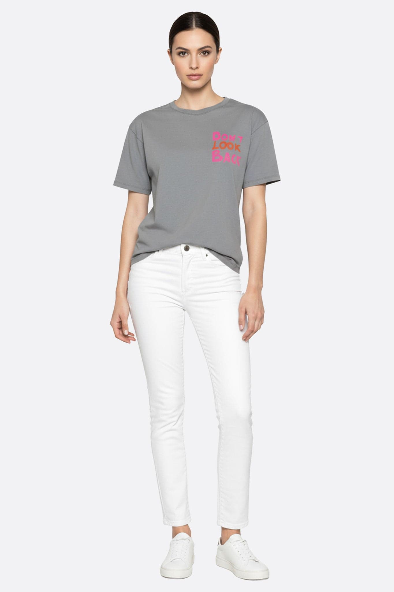 Detalle de la camiseta gris holgada con inscripción inspiradora, ideal para un look casual-chic en una salida urbana.