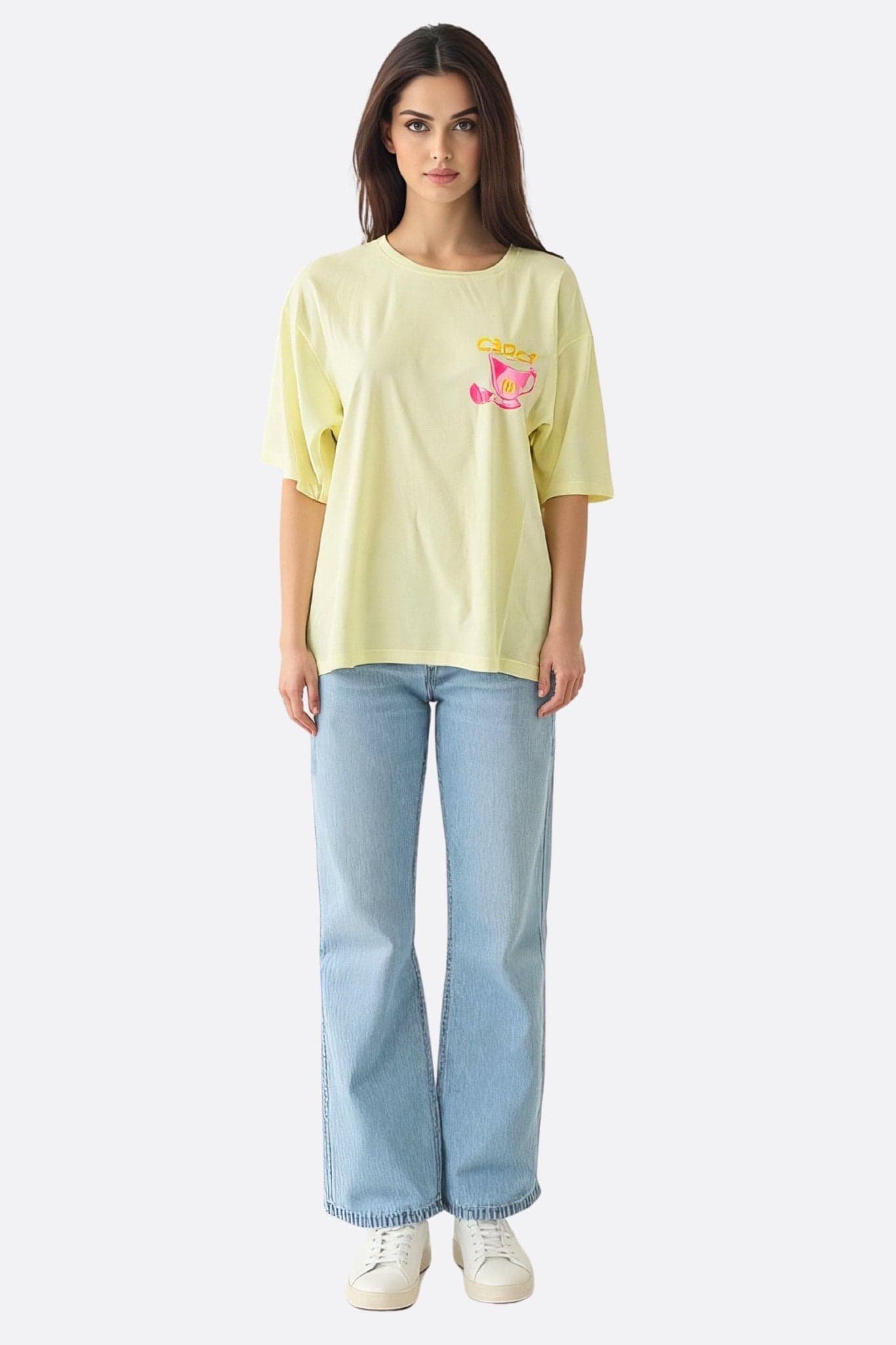 Zoom sur le t-shirt oversize jaune pastel, affichant un imprimé Capri, parfait pour une soirée décontractée et stylée.