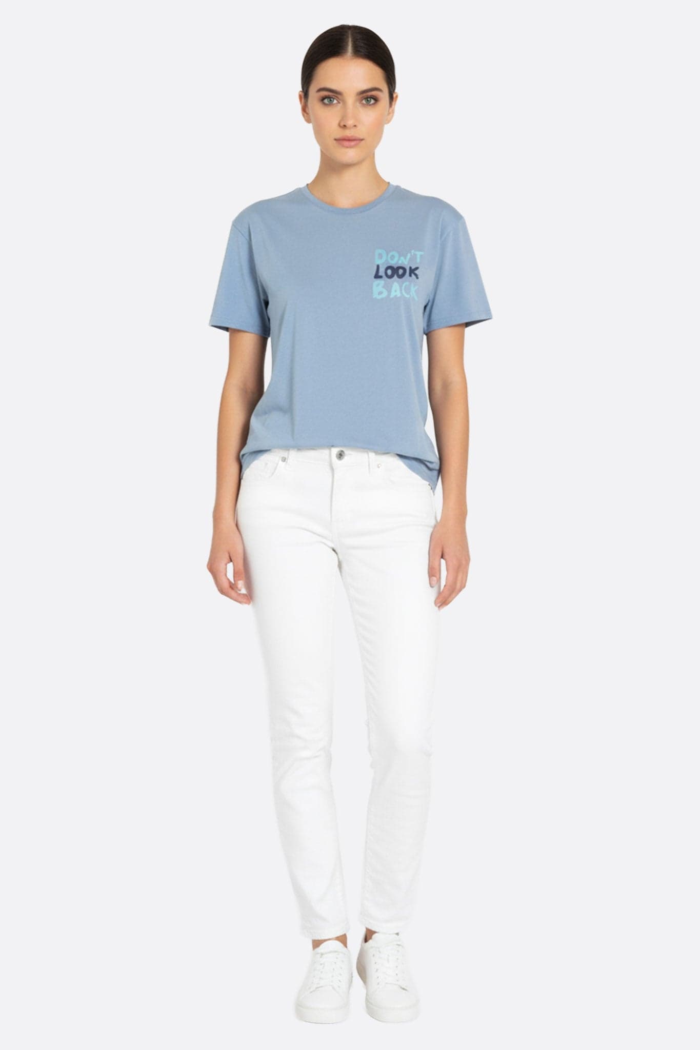 Dettaglio di una t-shirt oversize azzurro cielo con il messaggio ispirante "Don't look back", perfetta per un look chic e casual.