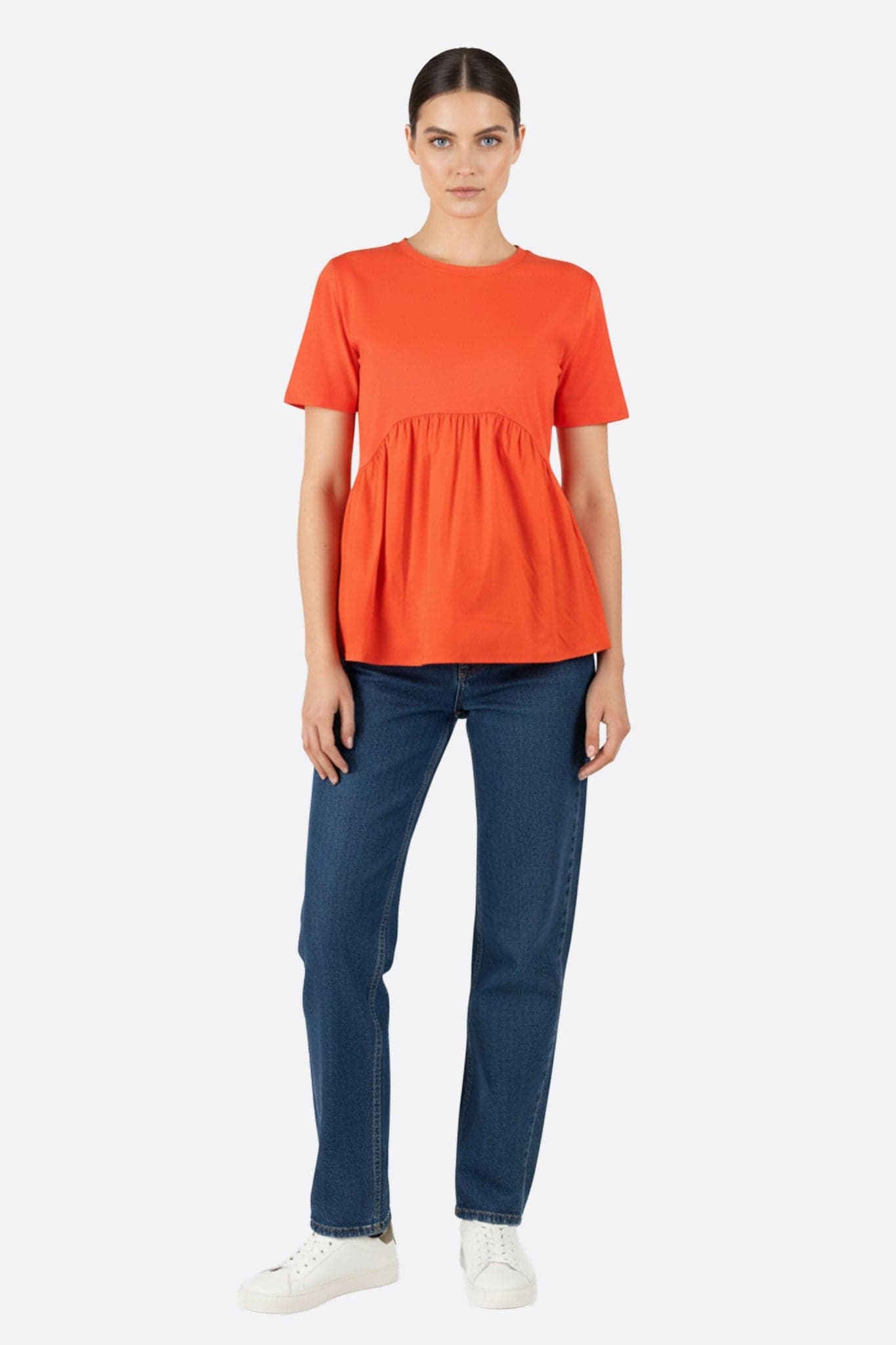 Detail of ruching on a coral oversized t-shirt, ideal for a modern and elegant look on any occasion.