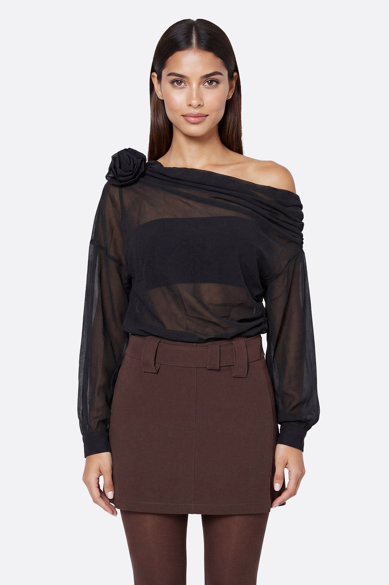 Front-facing model wearing an asymmetric black draped top in sheer voile with a sculpted flower on the shoulder