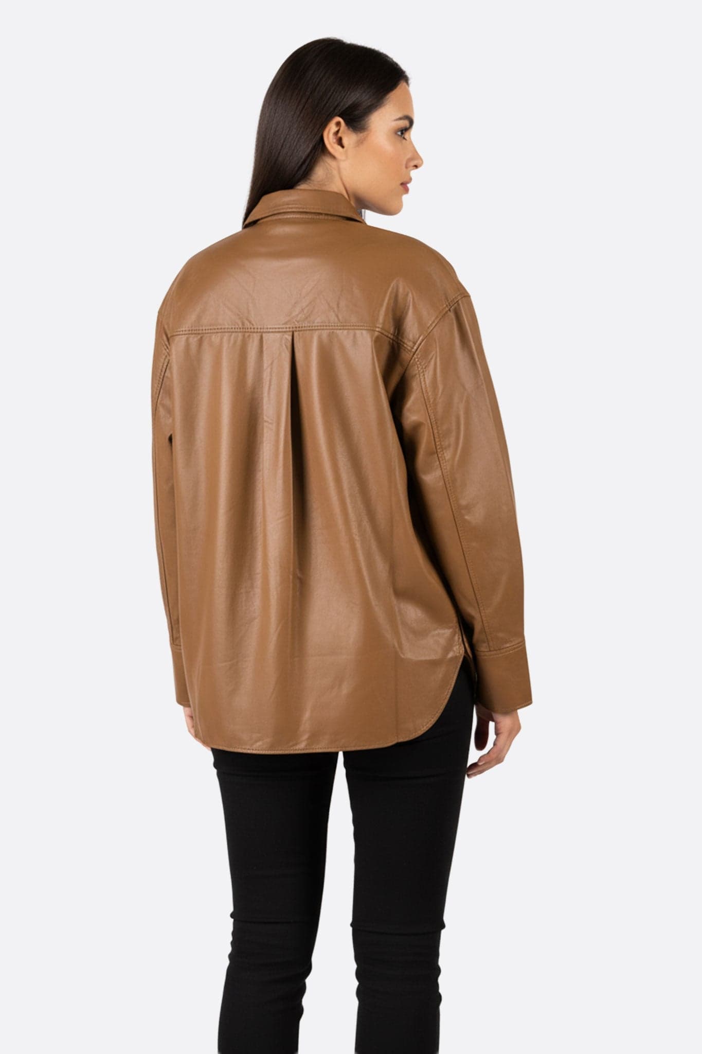 Dettaglio della finta pelle marrone della giacca-camicia oversize, un accessorio chic e alla moda per uno stile quotidiano elegante.