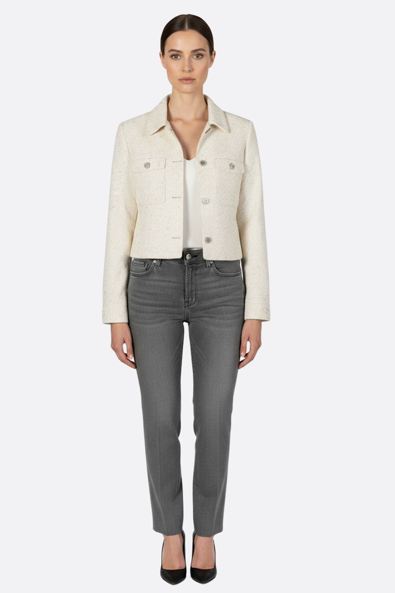 Zoom sur une veste courte en tweed écru ornée de sequins, un choix raffiné pour illuminer vos tenues de soirée.