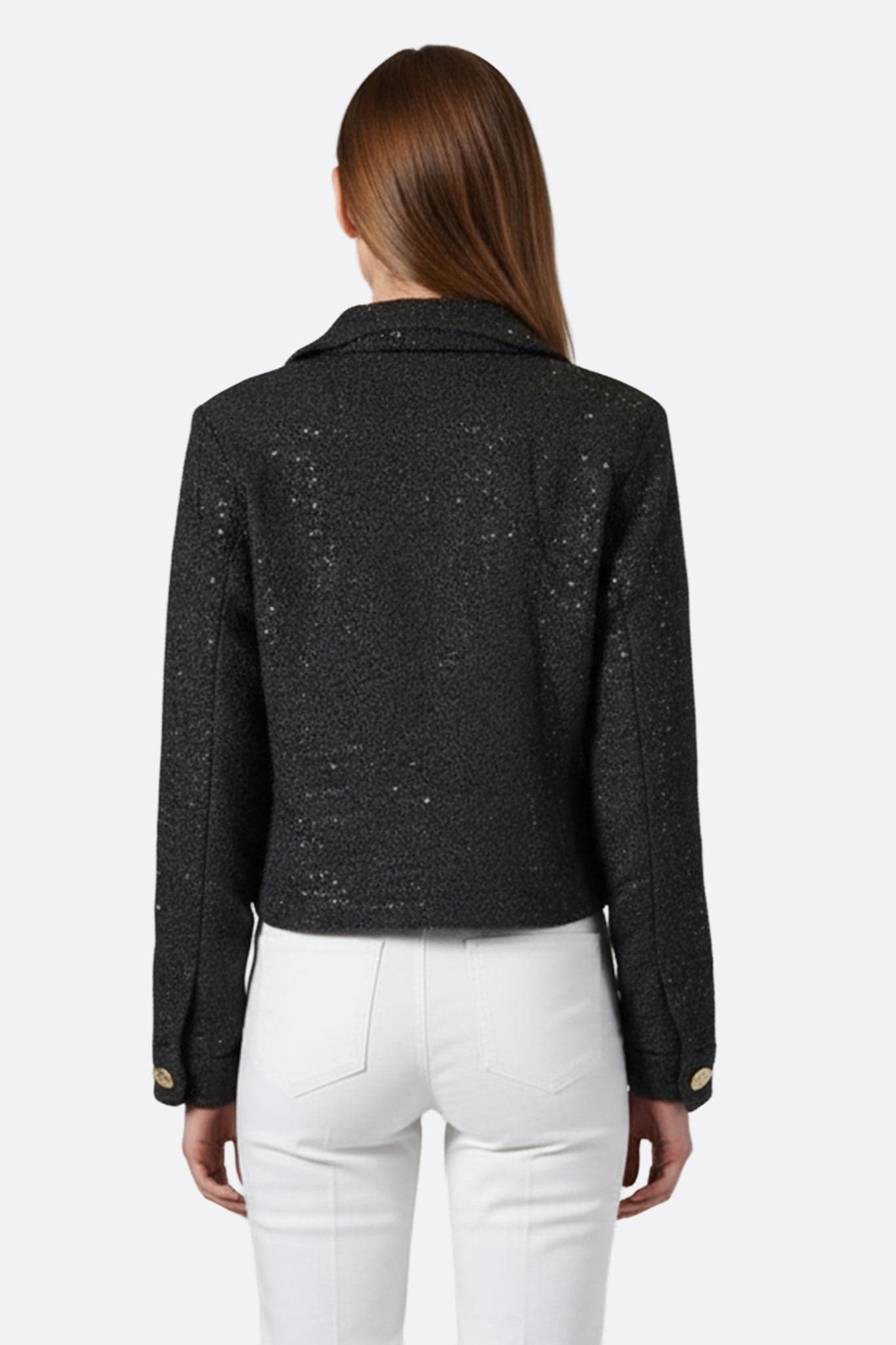 Detalle luminoso del chaquetín corto de tweed negro con lentejuelas, perfecto para un look chic en soirées elegantes.