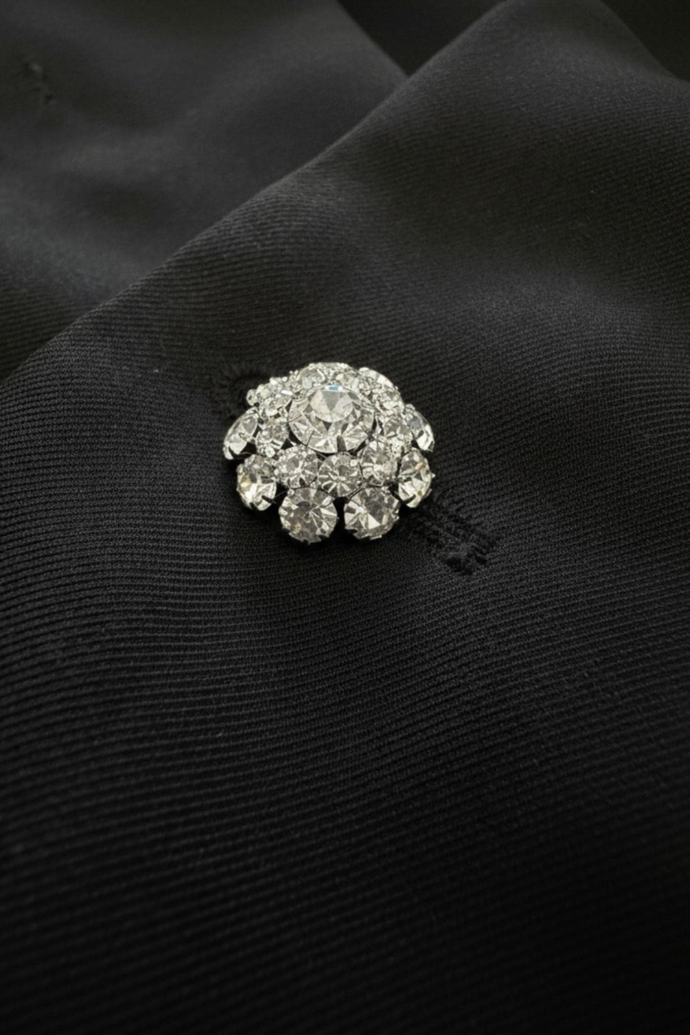 Faszinierendes Detail der Blütenblattärmel der schwarzen Jacke, verziert mit weißen Federn, verleiht einen Hauch von Eleganz...