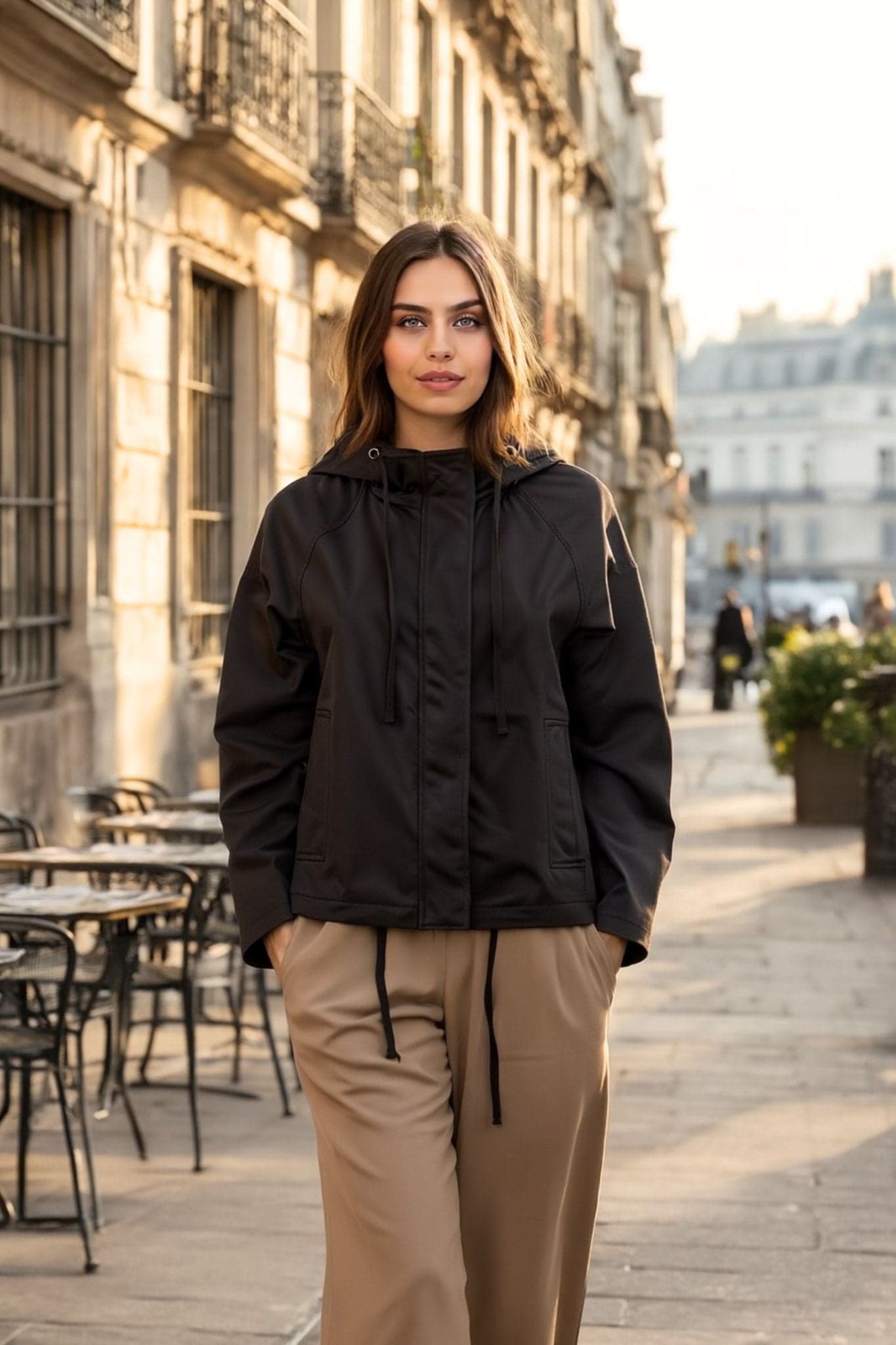 Detail of the fabric of the light black hooded jacket, showcasing its loose straight cut and refined style for...