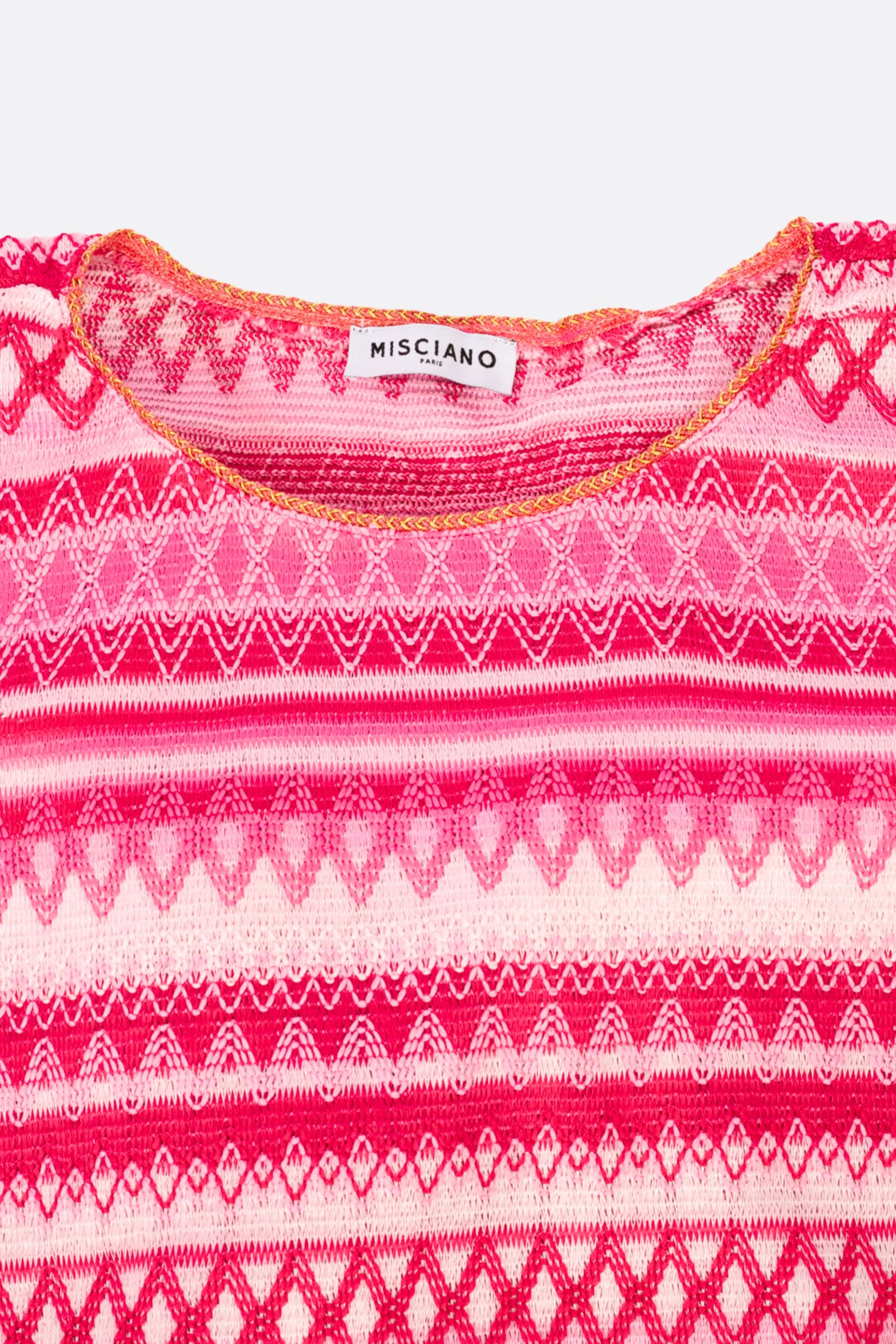 Dettaglio della tunica in maglia jacquard rosa, un abito chic e raffinato, ideale per occasioni eleganti e serate speciali.