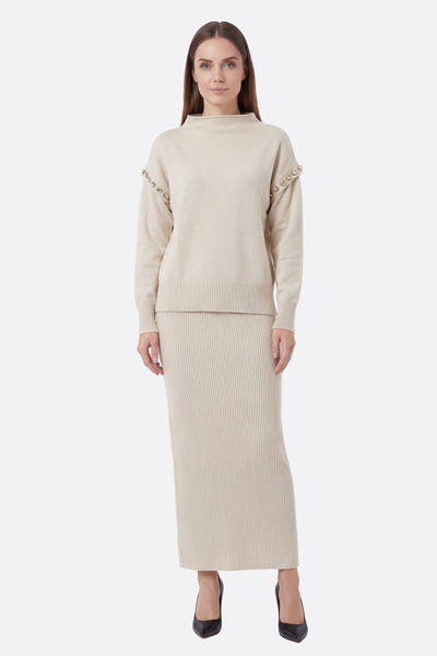 
Ensemble élégant en maille écru, jupe longue et pull à détails, parfait pour une sortie raffinée.



