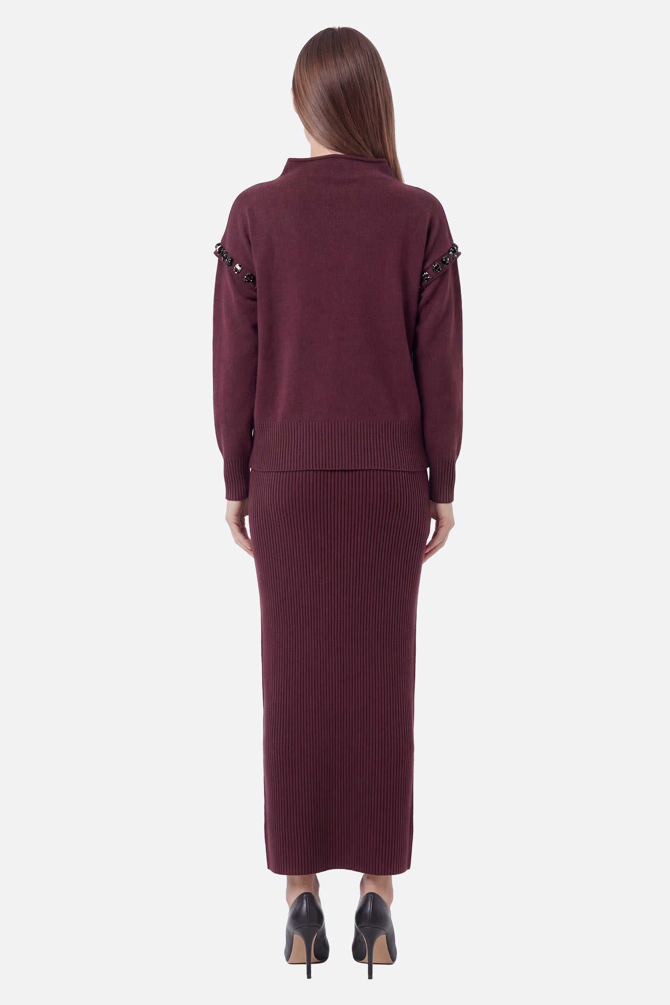 Détail rapproché de l'ensemble en maille bordeaux, jupe longue et pull col montant, parfait pour un look élégant au bureau.
