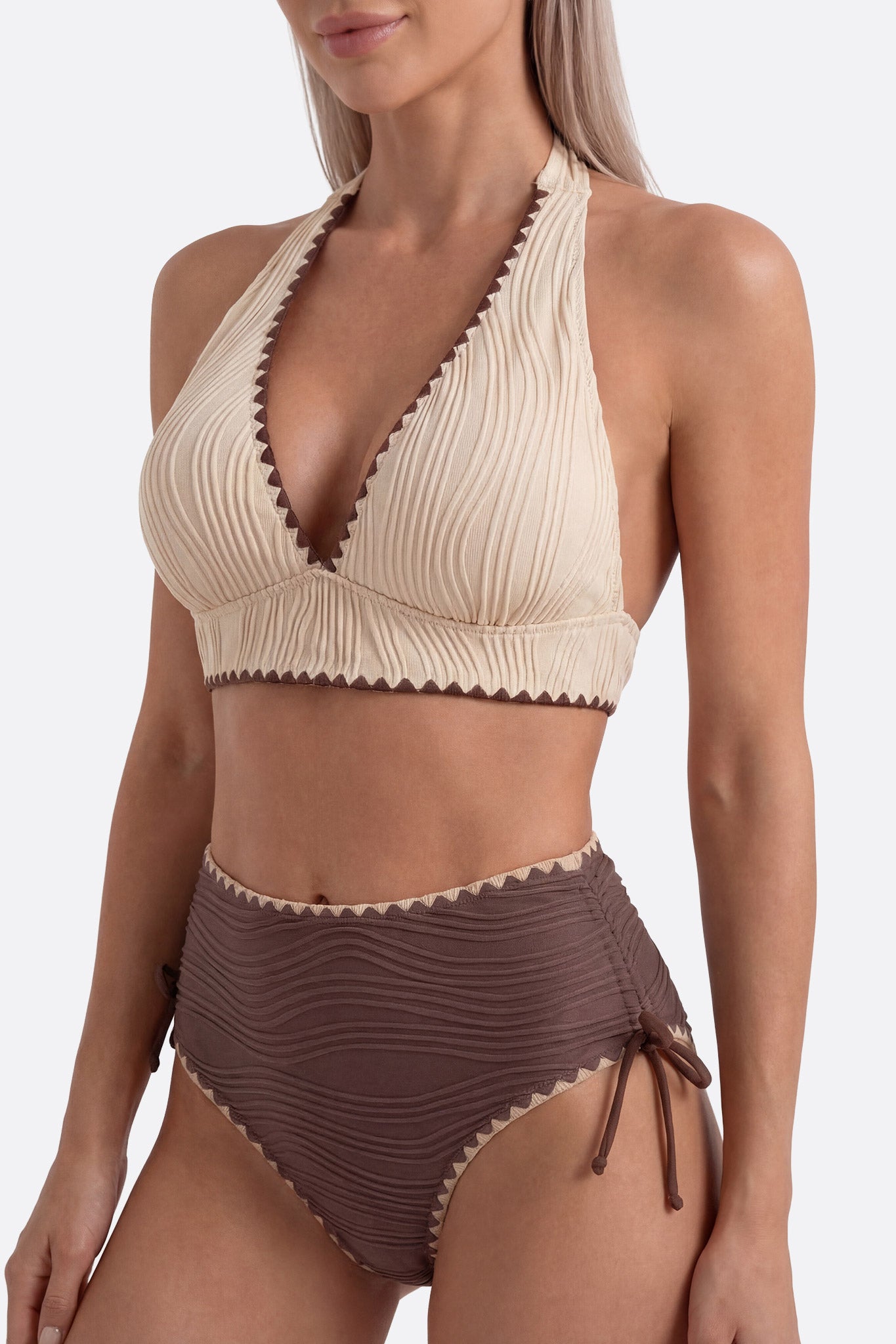 
Zoom sur le maillot de bain taille haute beige et marron, mettant en avant sa texture raffinée et son style élégant pour...



