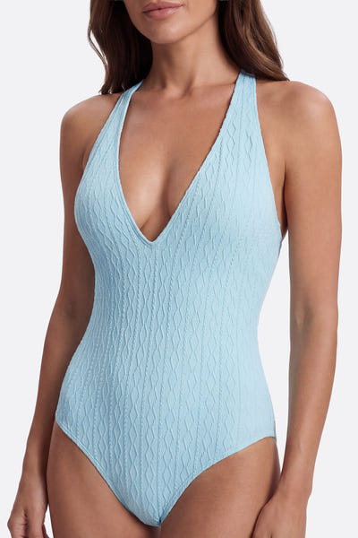 
Détail latéral d'un maillot de bain une pièce bleu turquoise texturé, parfait pour une journée à la plage.



