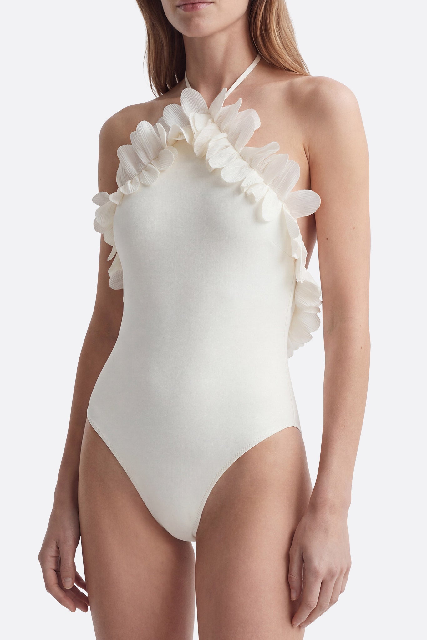 
Détail d'un maillot de bain une pièce blanc lumineux orné de volants stylés, parfait pour une journée à la plage chic.



