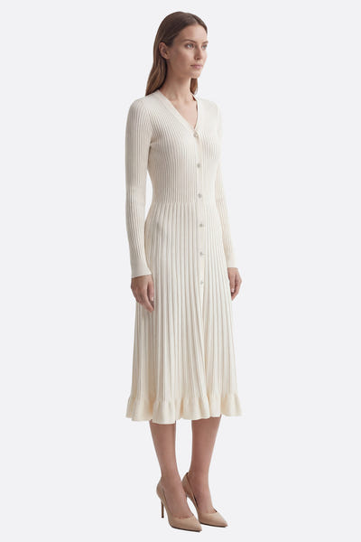 
Détail de la robe midi ivoire en maille côtelée, mettant en valeur son col en V et sa texture raffinée pour des...



