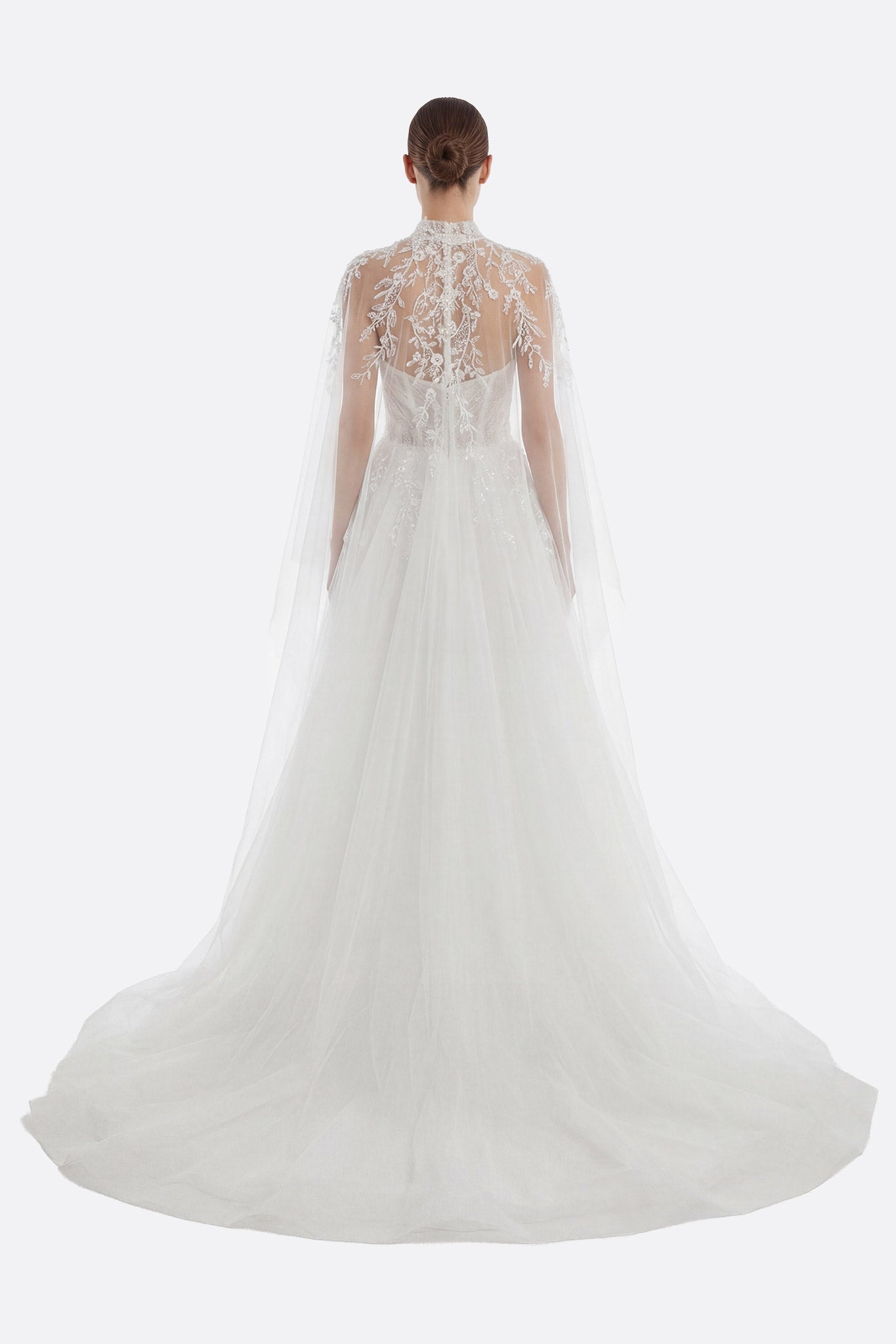 Graceful strapless tulle wedding dress with intricate embroidery, a daring slit skirt, and a detachable flowing cape.