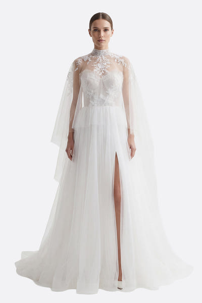 
Robe de mariée bustier en tulle fluide, corsage brodé et jupe fendue, avec une élégante cape amovible.



