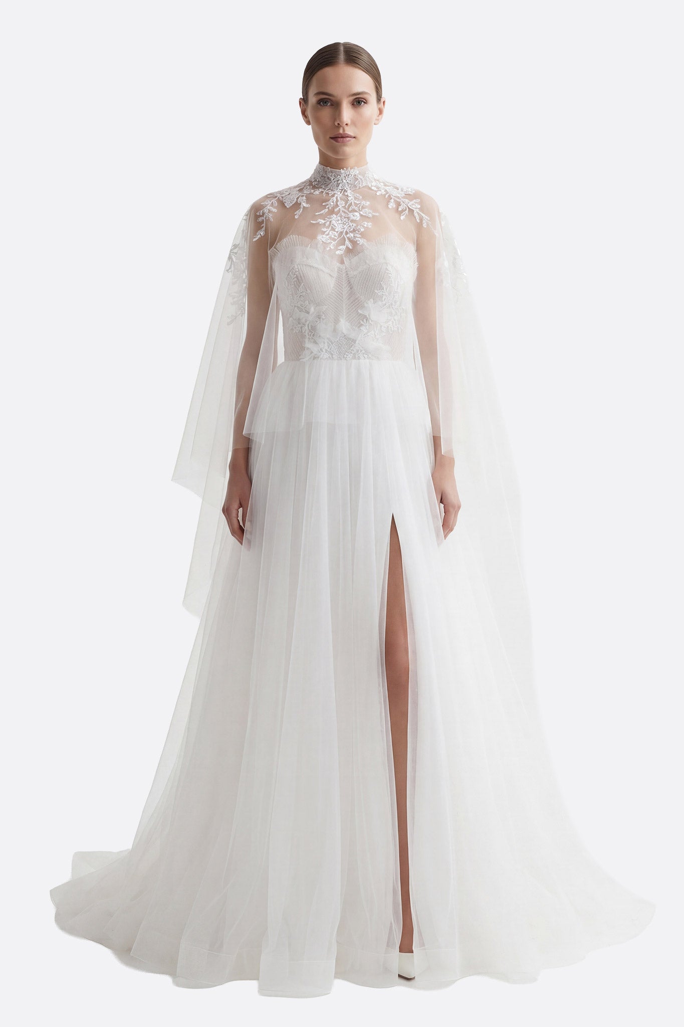 
Robe de mariée bustier en tulle fluide, corsage brodé et jupe fendue, avec une élégante cape amovible.



