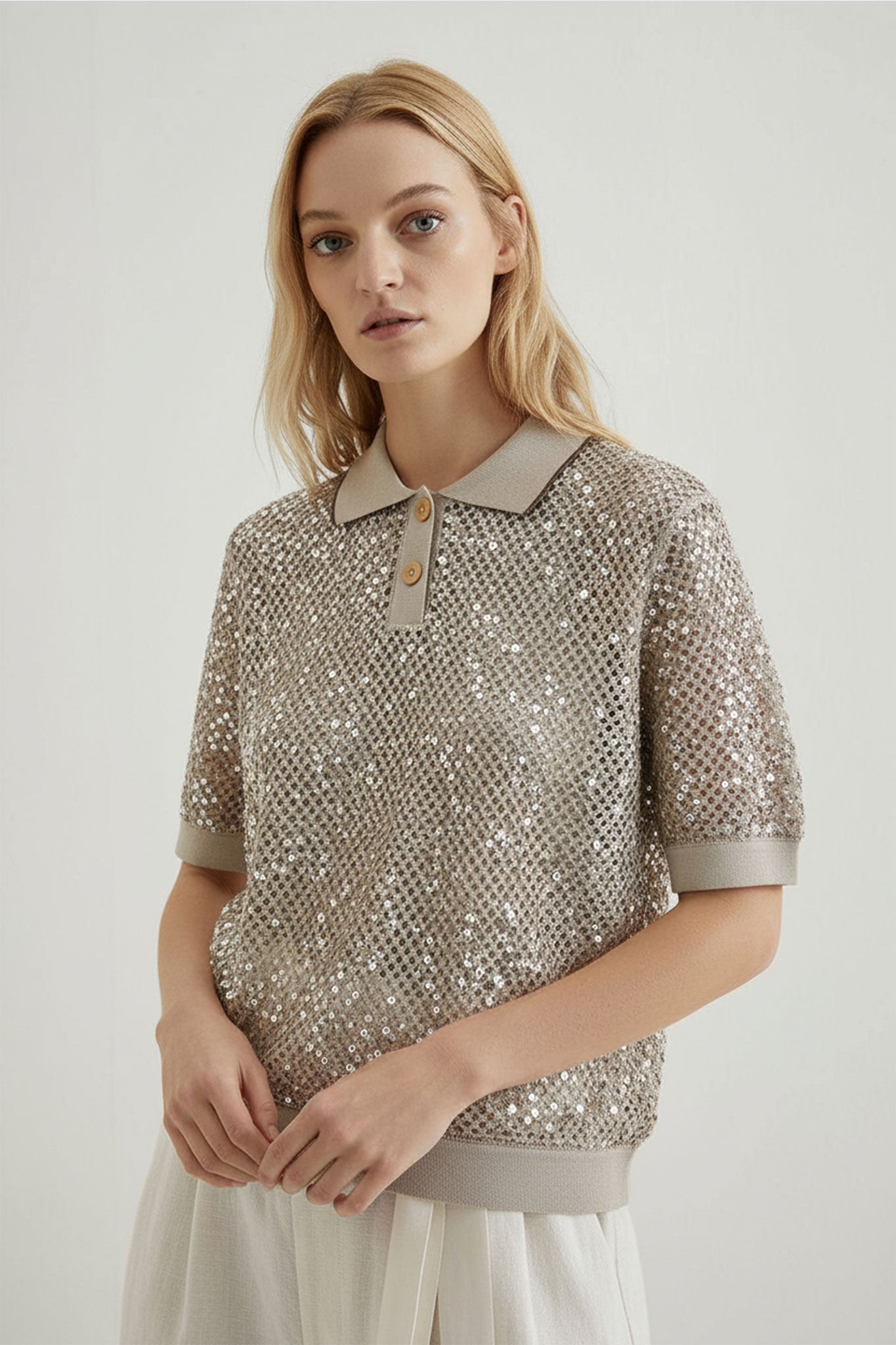 
Mise en avant des sequins ton sur ton sur un polo beige sablé en maille ajourée, parfait pour les soirées d'été raffinées.



