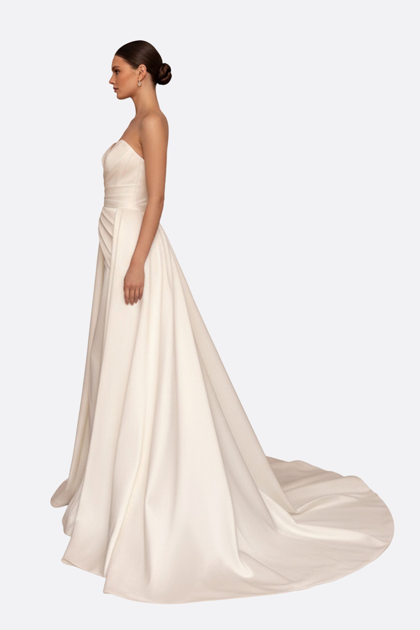 Détail d'une robe de mariée blanche bustier, mettant en avant la texture satinée et le mouvement élégant de la traîne.