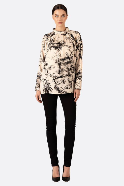 
Zoom sur le motif toile de Jouy noir et blanc de la blouse oversize, idéale pour un look chic en soirée ou au bureau.



