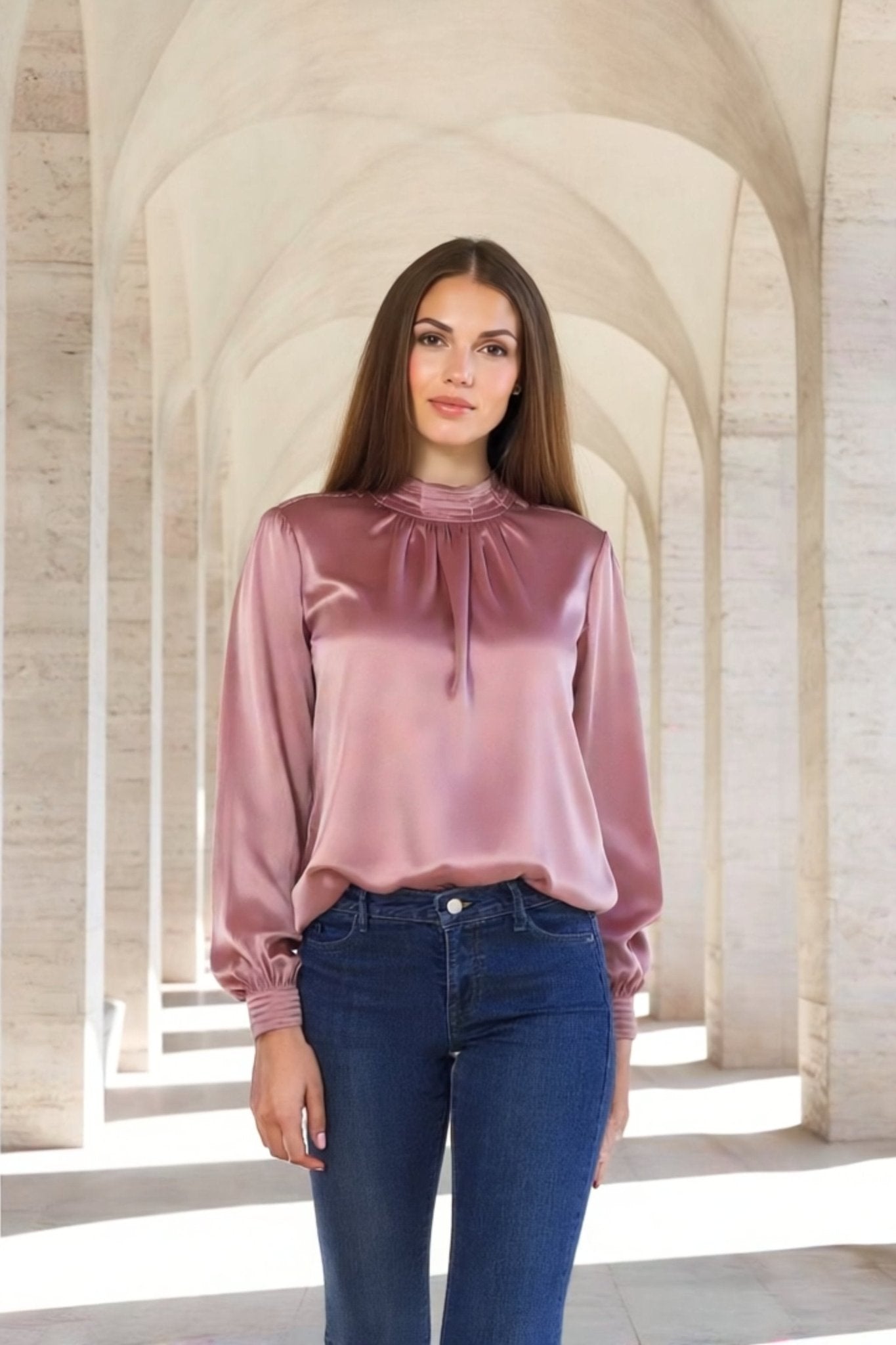 Dettaglio laterale di una blusa in satin rosa cipria con maniche lunghe e colletto arricciato, perfetta per look eleganti...