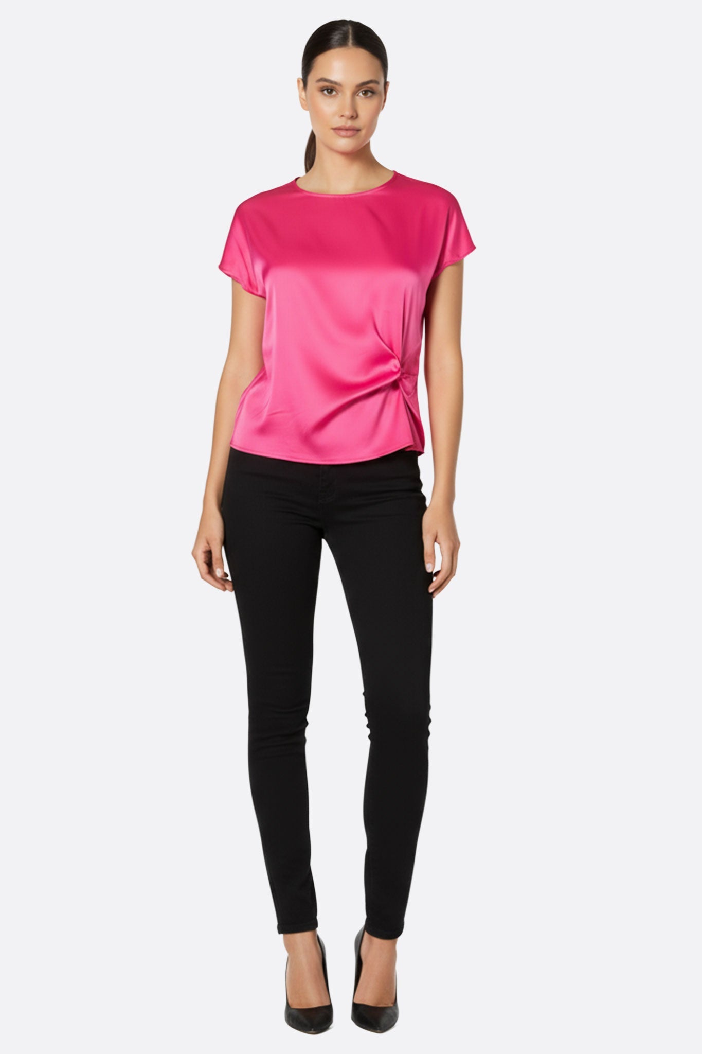 Dettaglio arricciato della blusa in satin fucsia, tessuto luminoso che cattura la luce per un look chic e femminile.