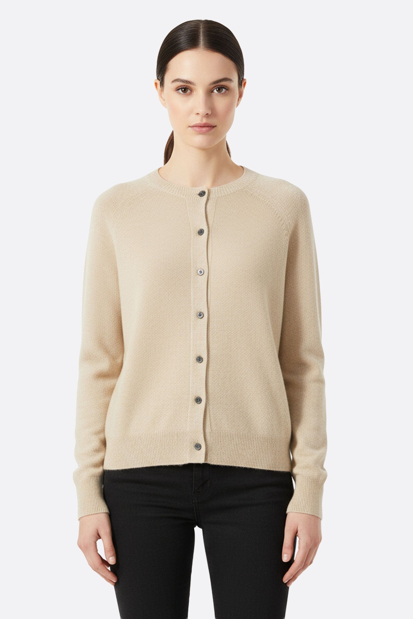 Cardigan en laine tricotée blanc crème à manches longues, mettant en avant la douceur de sa texture pour une allure élégante.