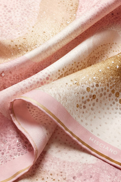 
Zoom sur les nuances dorées du carré de soie 90 Aurore rose poudrée, un accessoire élégant pour soirées raffinées.



