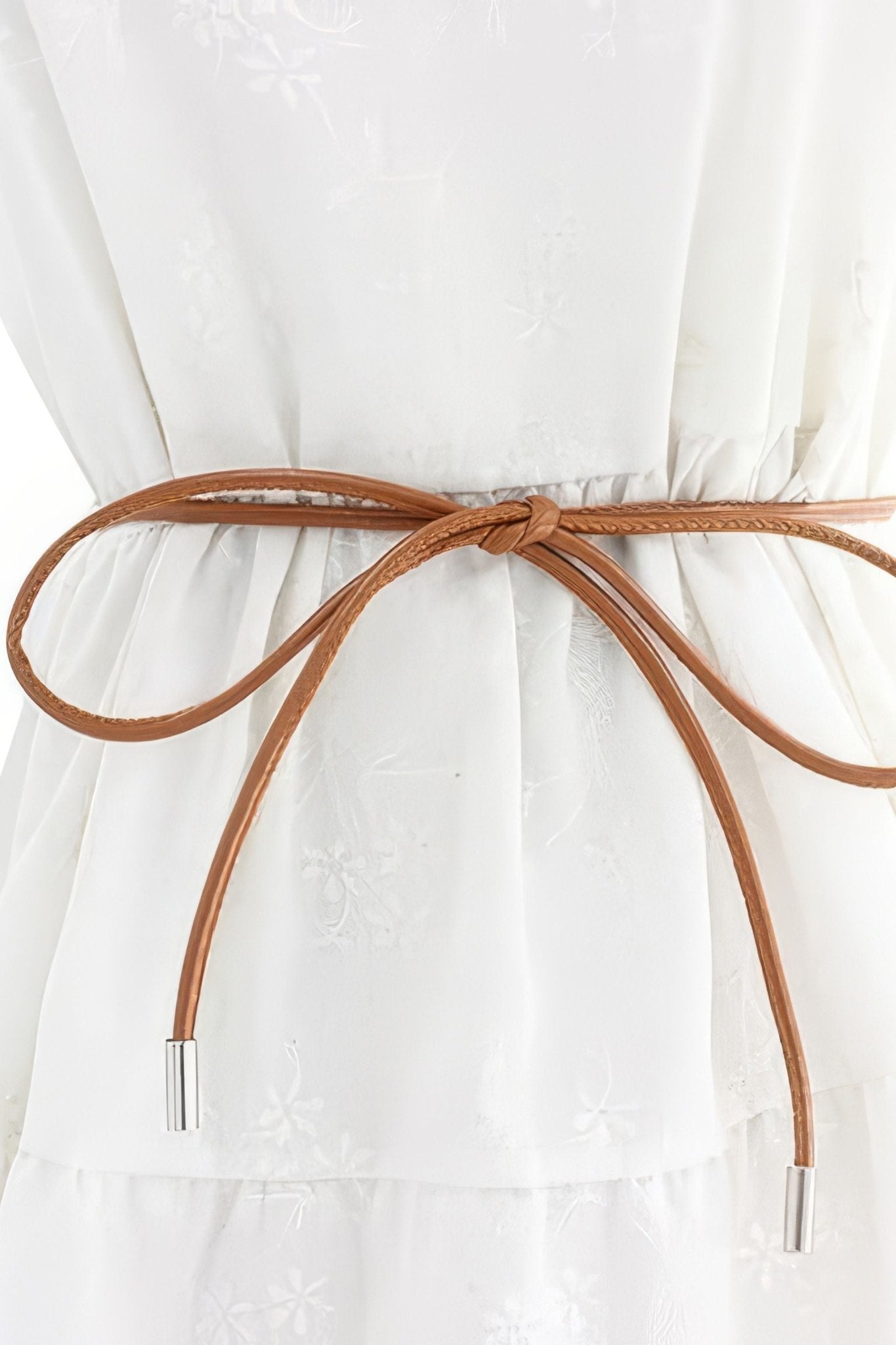 Ceinture cordon marron délicate aux embouts métalliques argentés, accessoire chic pour une allure raffinée et moderne.