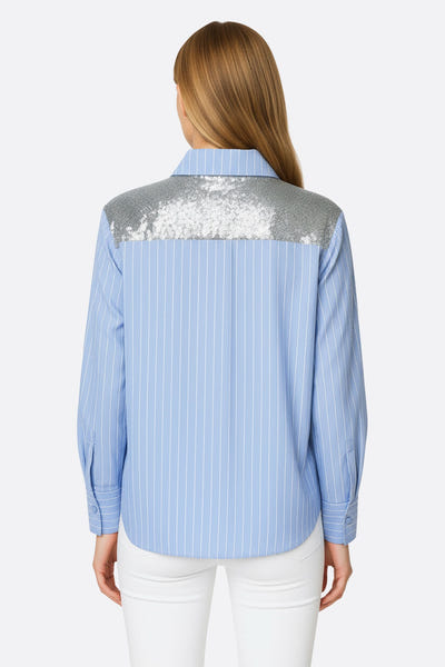 
Zoom sur les épaules pailletées d'une chemise rayée bleu ciel, ajoutant une touche glamour à une tenue de soirée élégante.



