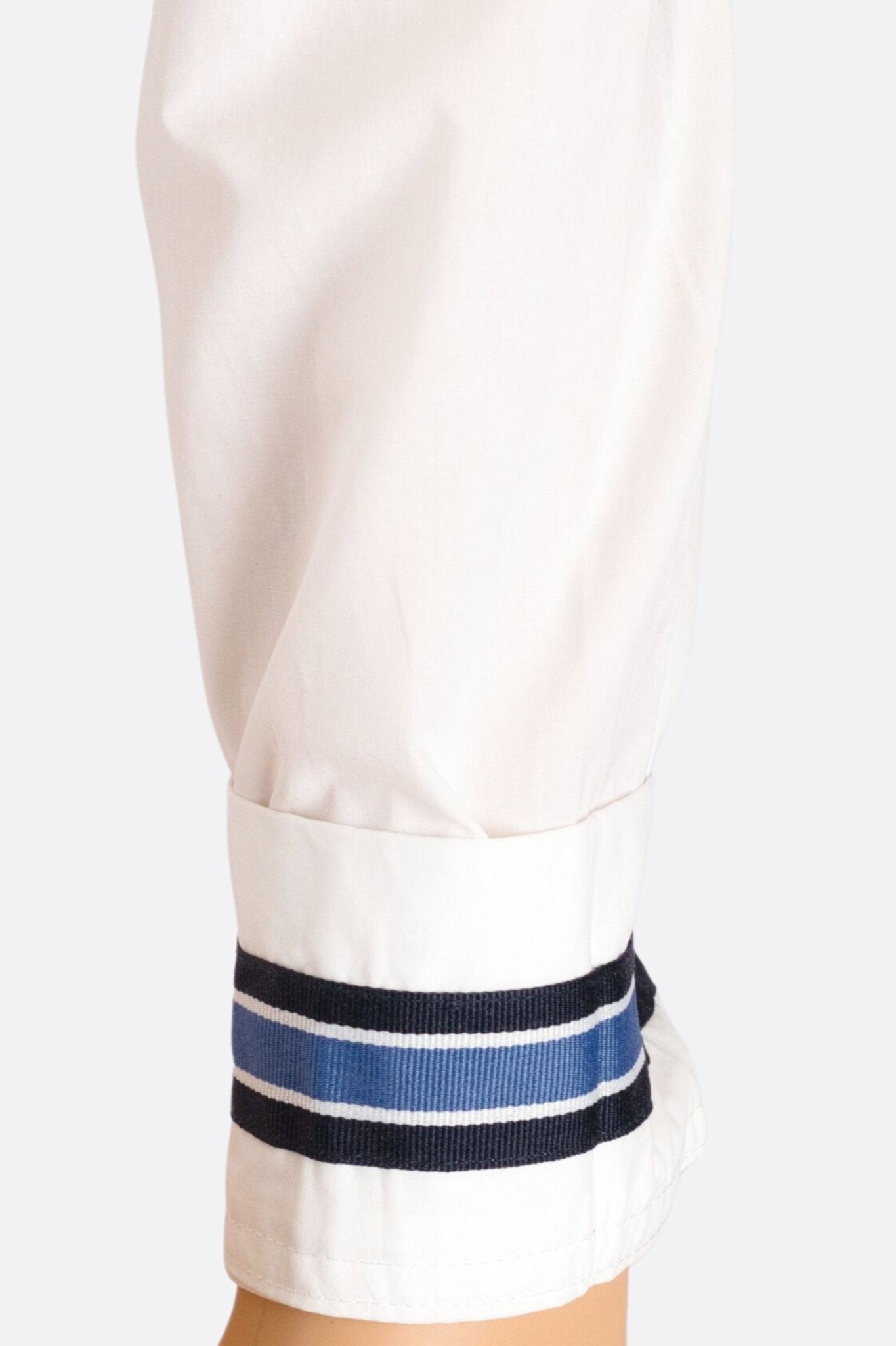 
Poignets à rayures de la chemise blanche cintrée, ajoutant une touche chic pour des événements formels ou professionnels.



