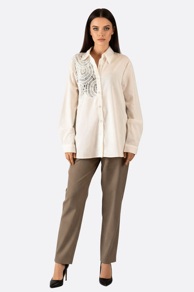 
Détail de la chemise blanche en coton avec dentelle ajourée, une pièce élégante pour un style contemporain et raffiné.



