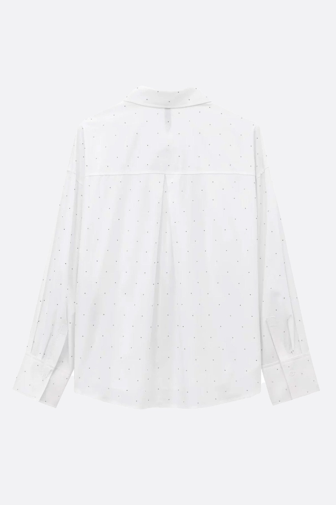 
Détail de la chemise blanche oversize twill avec strass, parfaite pour des soirées élégantes ou un style décontracté chic.



