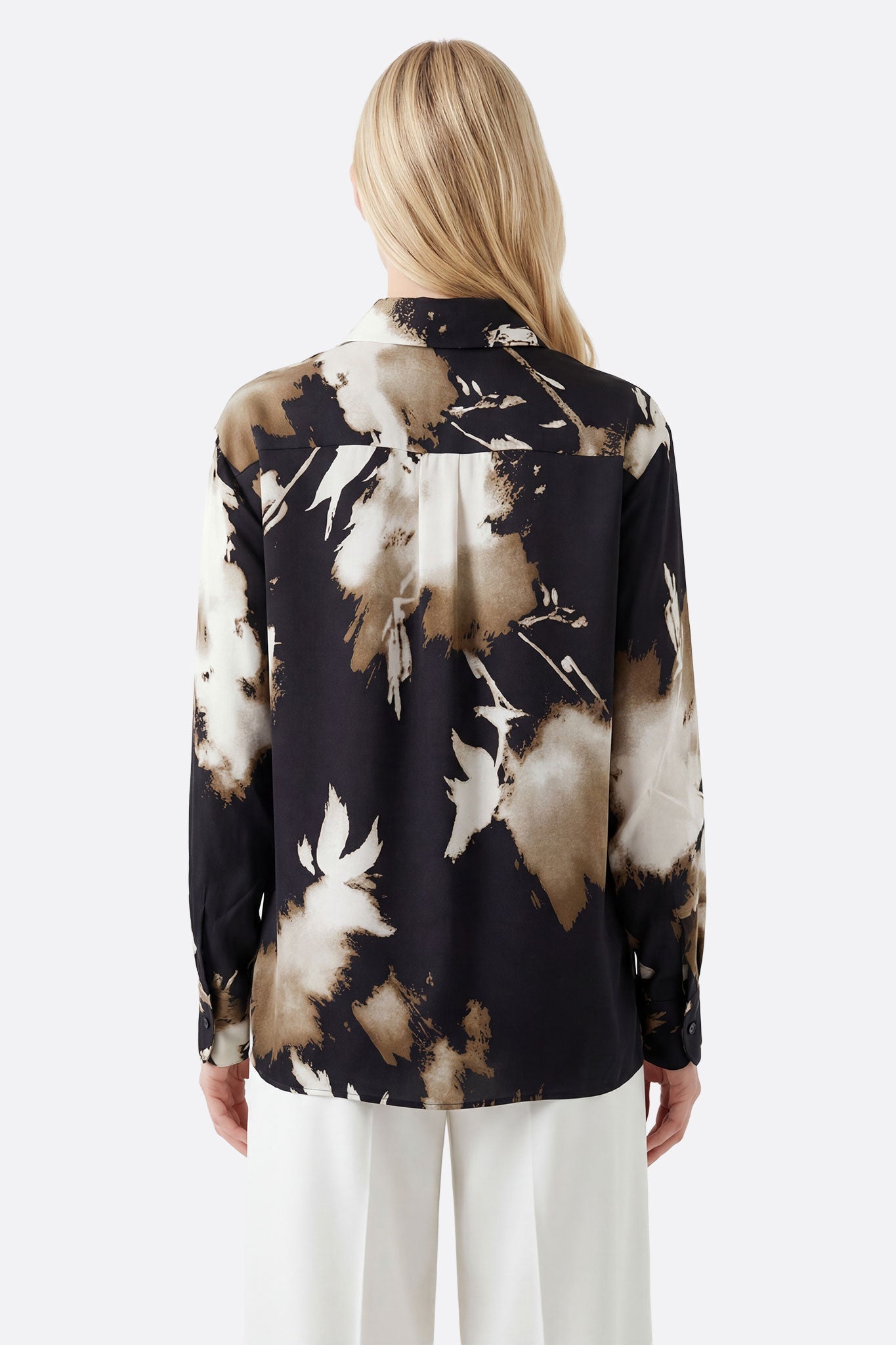 Détail de la chemise fluide noire en viscose, mettant en avant l'imprimé abstrait beige, parfaite pour une sortie élégante.