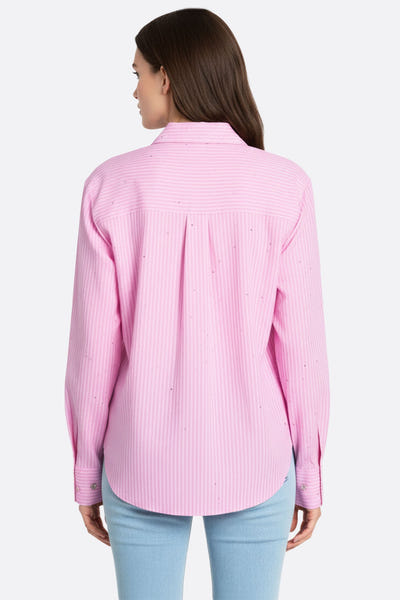 
Zoom sur la chemise rose à rayures fines, mettant en lumière les strass étincelants pour une allure élégante en journée.




