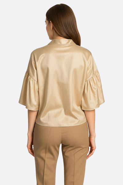 
Zoom sur la chemise en satin beige à nouer, révélant une texture douce et lumineuse, parfaite pour un look raffiné au...



