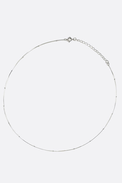
Zoom sur le collier ras-du-cou en argent 925, mettant en valeur les fines perles argentées pour une allure élégante.



