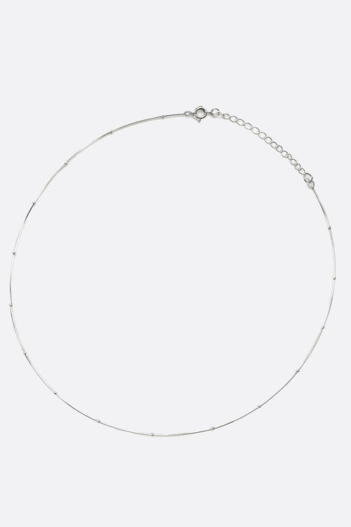 
Zoom sur le collier ras-du-cou en argent 925, mettant en valeur les fines perles argentées pour une allure élégante.



