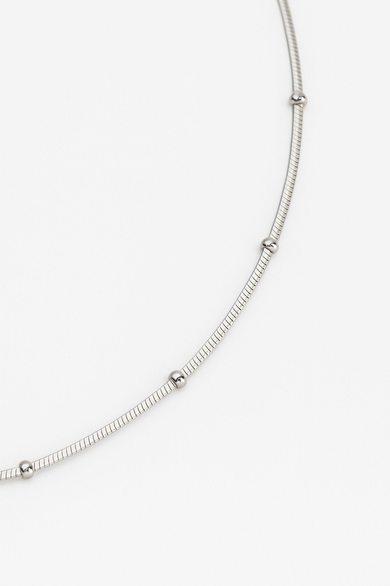 Perspective alternative du collier ras-du-cou en argent 925, mettant en avant les détails raffinés des perles argentées.