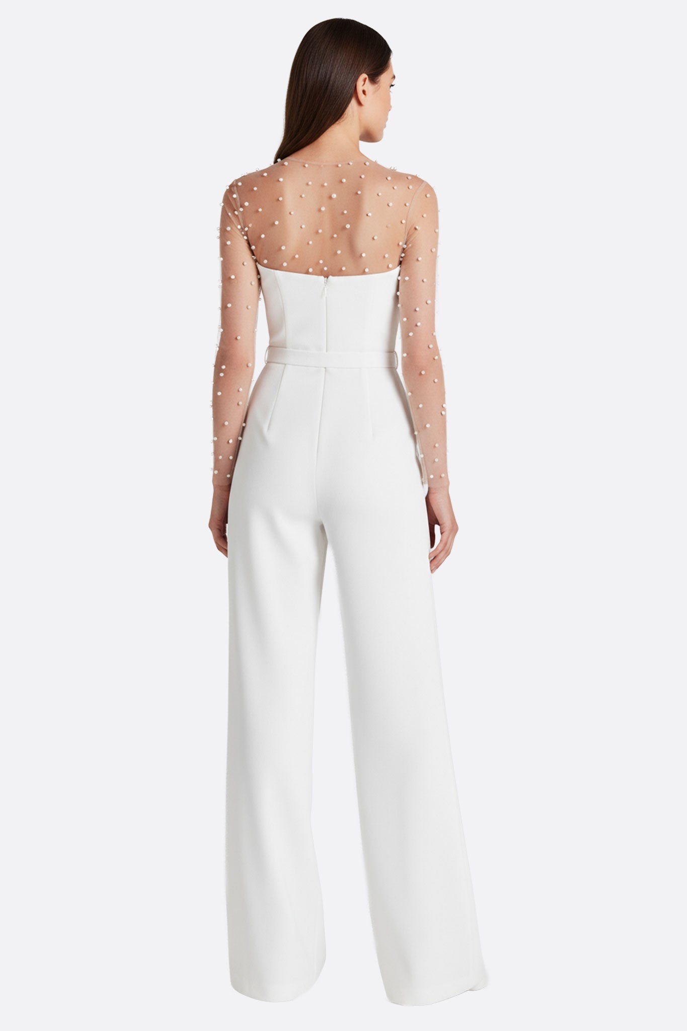 
Détail angulaire de la combinaison blanche bustier avec manches illusion perlées, un choix chic pour un mariage stylé et...



