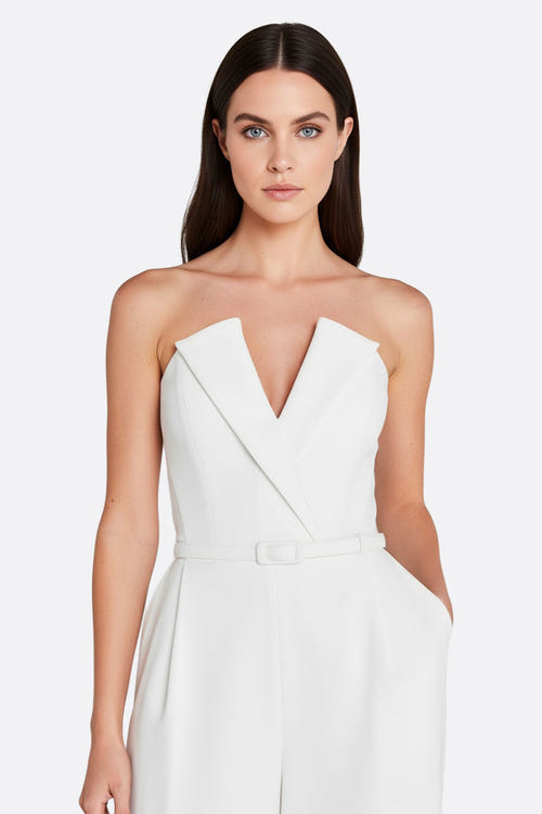 
Zoom sur les manches illusion perlées de la combinaison blanche bustier, une pièce raffinée pour un mariage élégant et...



