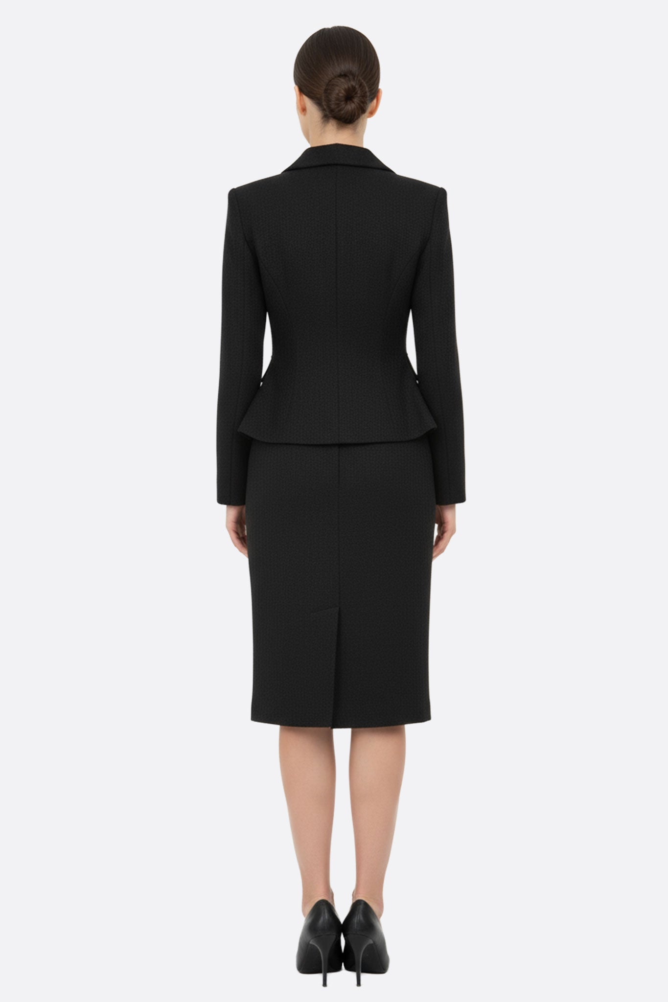 Feminine black fitted skirt suit featuring a chic jacket, displayed from a 3/4 angle, suitable for upscale gatherings or...