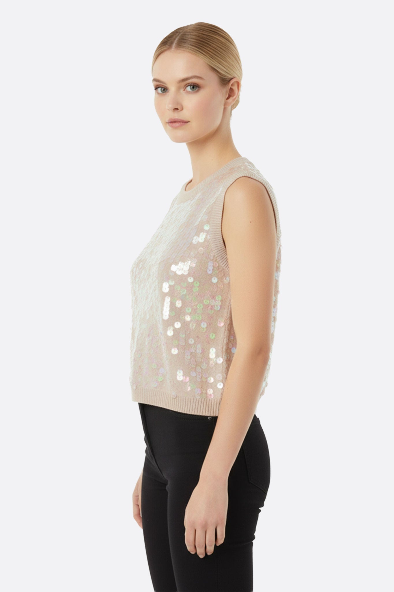 
Zoom sur le débardeur à sequins irisés beige et rose poudré, ajoutant une touche glamour à un look estival.



