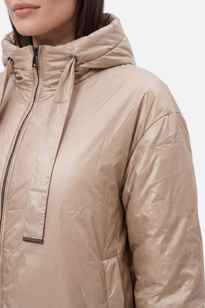 
Doudoune beige en satin, vue latérale sur la capuche et les liens ajustables, parfaite pour l'hiver chic et élégant.



