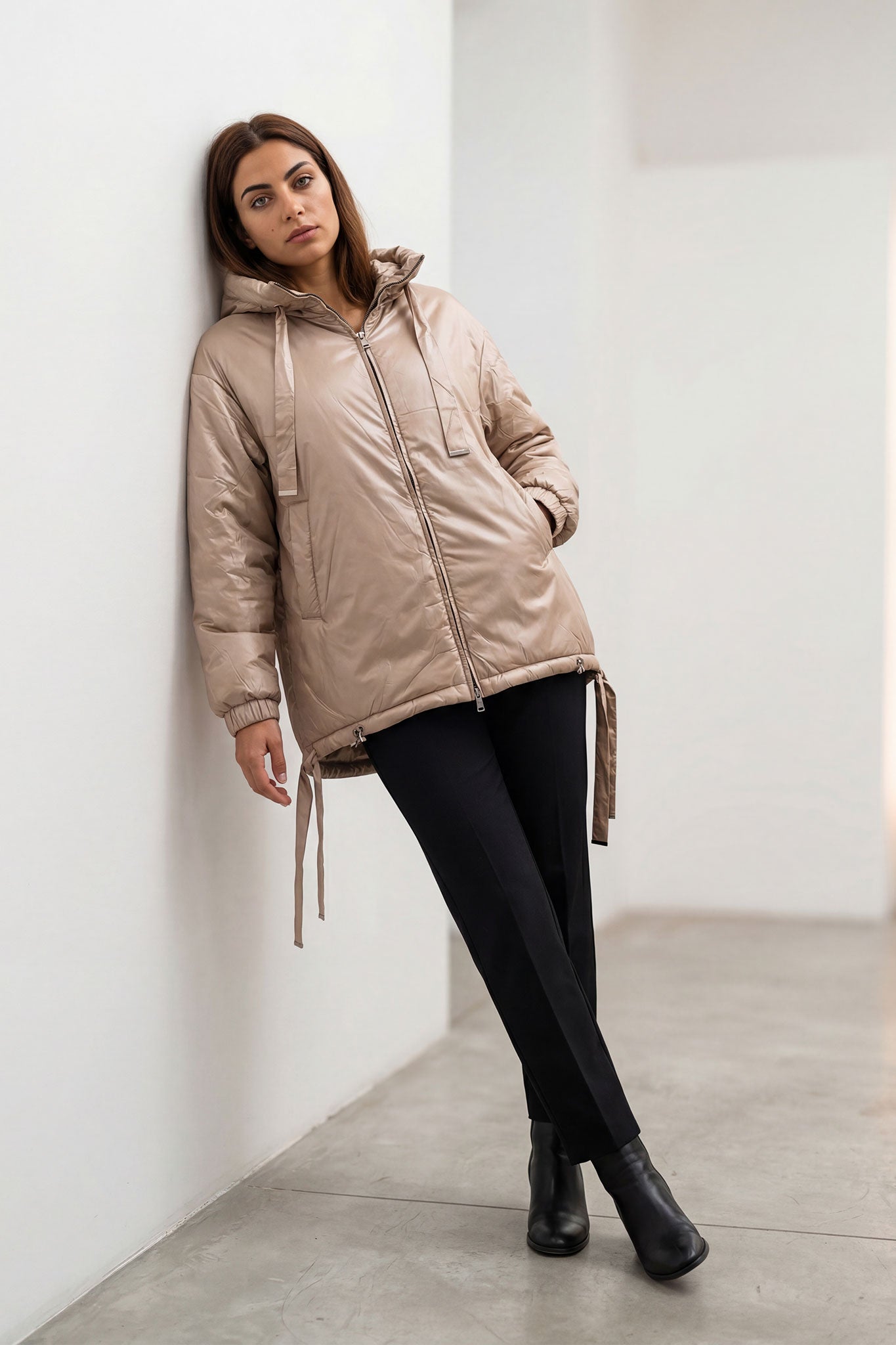 
Doudoune beige satinée avec capuche, détail des liens ajustables et de la texture matelassée, idéale pour une sortie...



