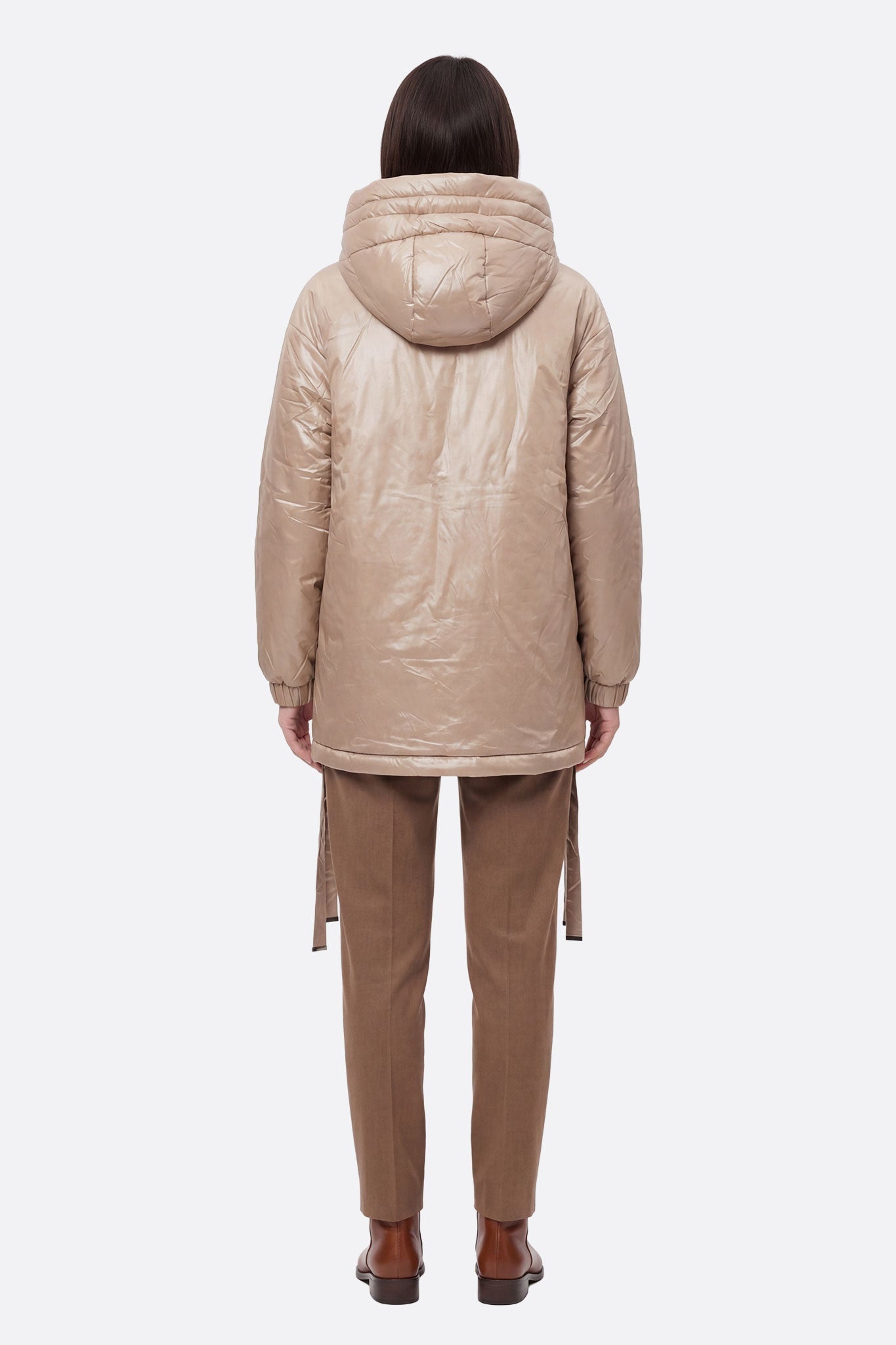 
Doudoune beige brillante à capuche, zoom sur le matelassage et les liens ajustables, parfaite pour un hiver raffiné.



