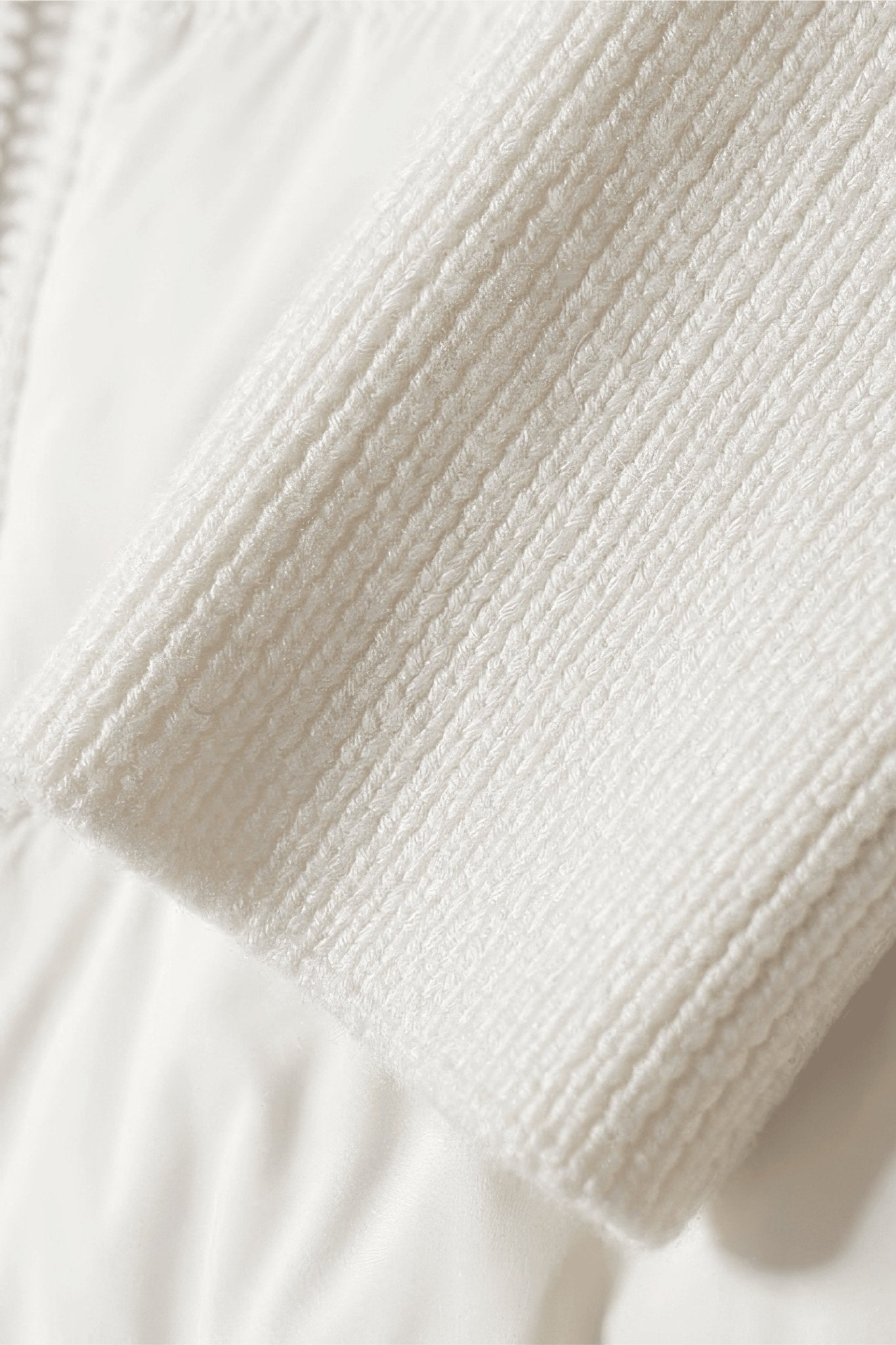 Elegant white hybrid down jacket with a refined hood, exemplifying comfort and style for the modern winter wardrobe.