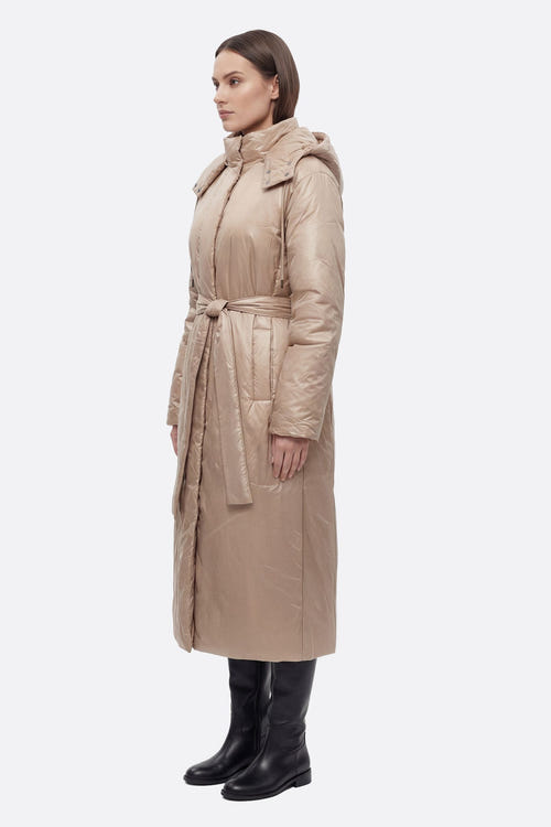 
Zoom sur la doudoune longue nacrée beige, mettant en avant sa ceinture et sa finition satinée pour un style chic et raffiné.



